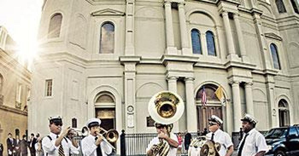 A brass band plays in front of St. Louis Cathedral