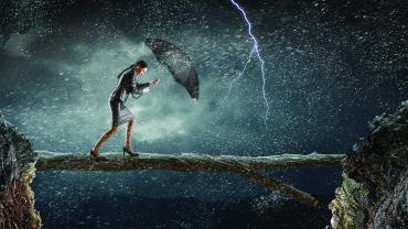 Woman with umbrella walking into a storm.
